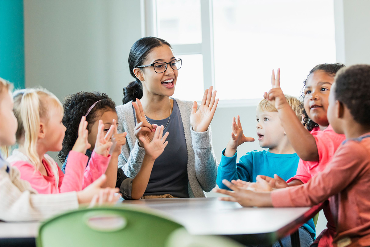 Children at a desk with a teacher